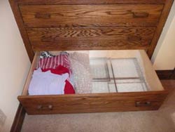 Window inserts are stored in a drawer next to sweaters.