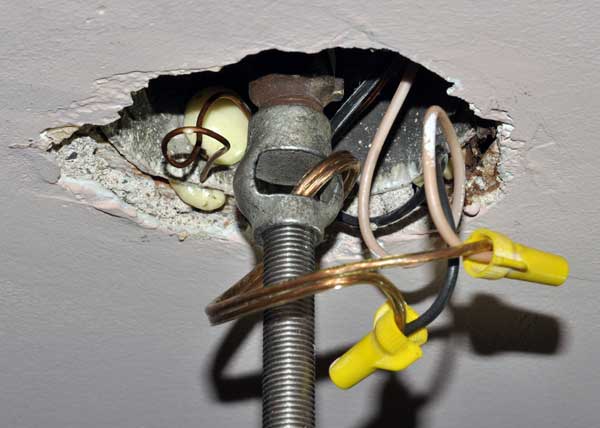 A light fixture connected to a ceiling electrical box using a hickey.