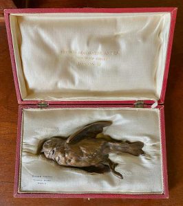 Bronze sculpture of a dead bird.