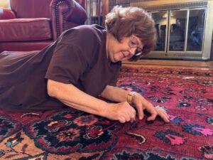 Deborah on floor, sewing.