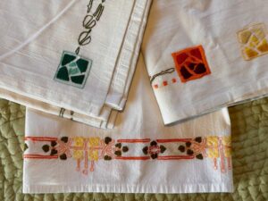 Three embroidered fabrics.