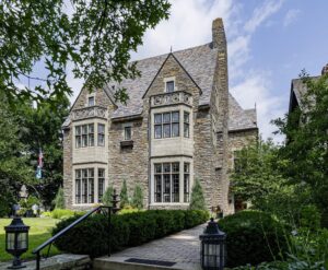 Large stone house with chimney on side.