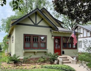 Exterior of a tan bungalow.