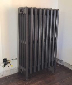 This salvaged, refurbished radiator has been moved into place and is ready for installation.