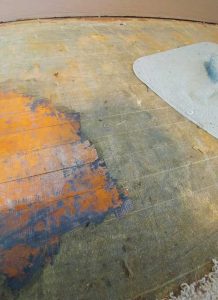 Photo of layers of gunk on the floor.