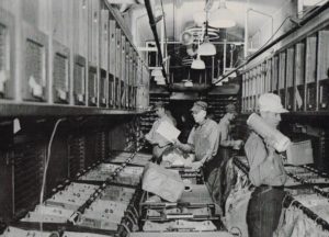 men sorting mail in a train car