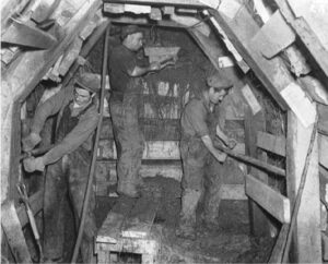 3 men working in a tunnel.