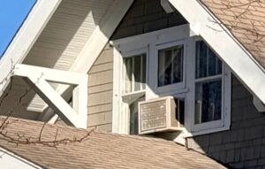 Closeup of gable with window air conditioner.